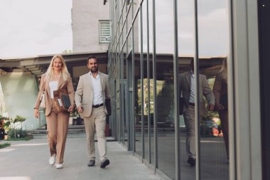 Uzun bir çalışmadan sonra modern iş çifti, evlerinin rahatlığı için birlikte yürüyorlar, profesyonel başarı ve kişisel memnuniyetin mükemmel bir karışımını oluşturuyorlar..