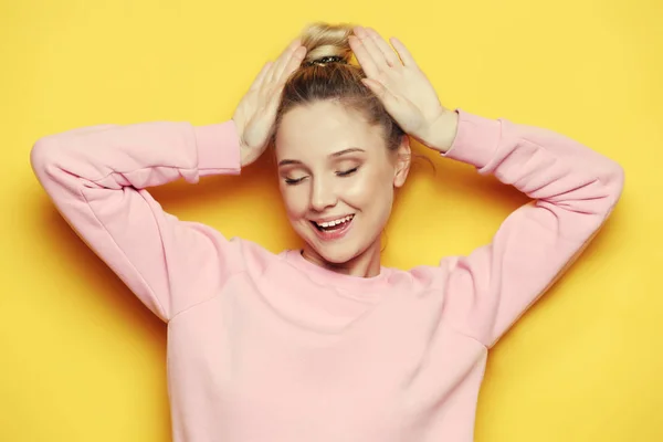 Young blond woman with closed eyes, over yellow background — Stock Photo, Image