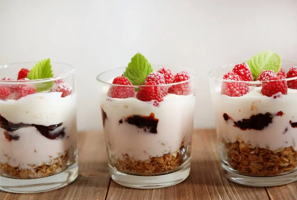 Desayuno saludable yogur con bayas frescas y muesli servido en frasco de vidrio, sobre fondo de madera —  Fotos de Stock