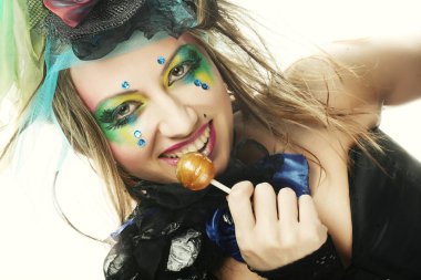 Yaratıcı makyajlı kız lolipop tutuyor.