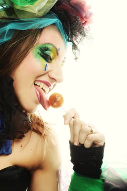 Yaratıcı makyajlı kız lolipop tutuyor.