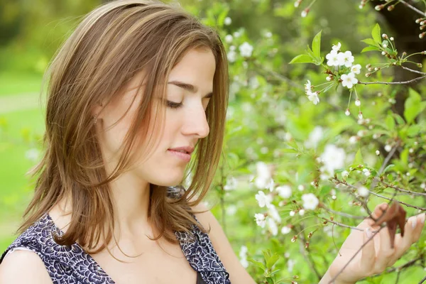 Jonge vrouw in jurk ontspannen in de tuin — Stockfoto