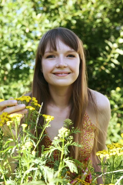 Kobieta siedząca na zewnątrz uśmiechnięta — Zdjęcie stockowe