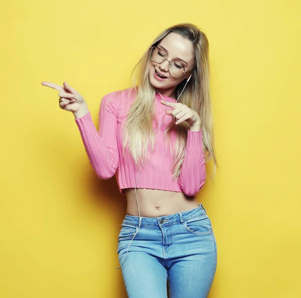 Lifestyle and people concept - Portrait of a pretty blond girl pointing finger — Stock Photo, Image