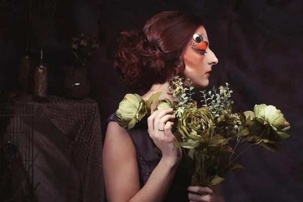 Primer plano retrato pelirrojo mujer con brillante creativo maquillaje celebración de flores secas — Foto de Stock