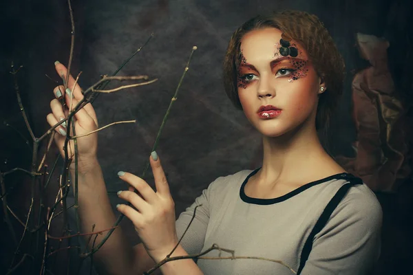 Schönheits- und Kunstkonzept: junge Frau mit hellem Make-up und trockenen Zweigen — Stockfoto