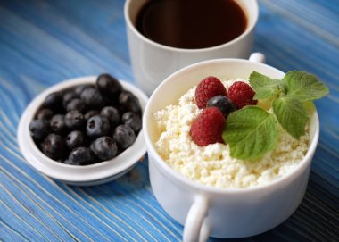 Berry ve nane, yaban mersini ve ahşap masa kahve Rus süzme peynir.