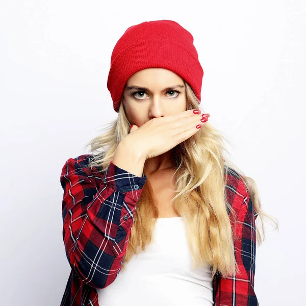 Lifestyle concept. young hipster blonde woman with bright sexy make up wearing stylish urban plaid shirt and red hat, white background. — Stock Photo, Image