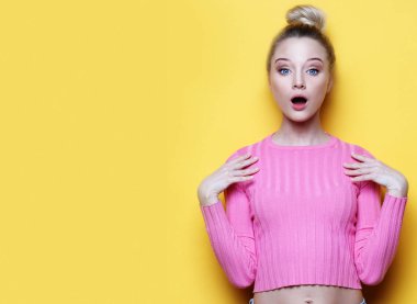 Sarı arka plan üzerinde bağırarak sürpriz genç sarışın bir kadın. Kameraya bakarak.