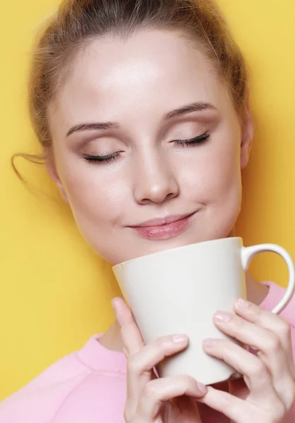 Молода блондинка тримає білу чашку з чаєм або кавою, способом життя та концепцією їжі . — стокове фото