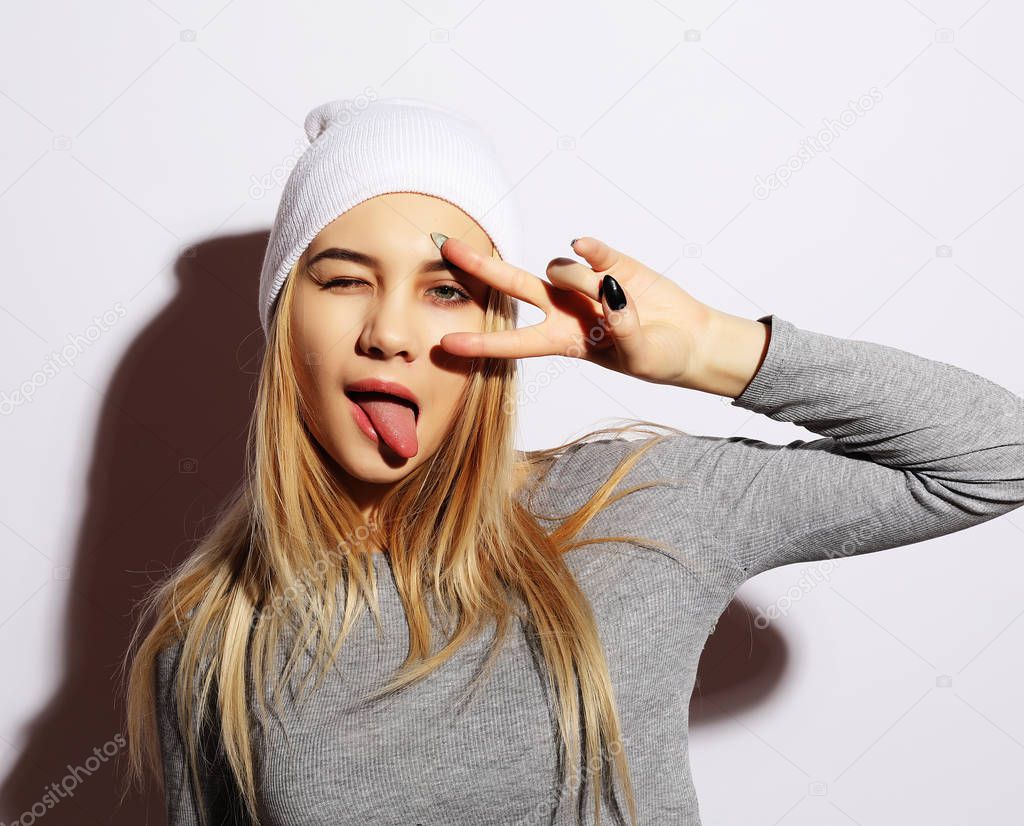 Emotional girl. Beautiful modern model shows tongue. Emotions on face