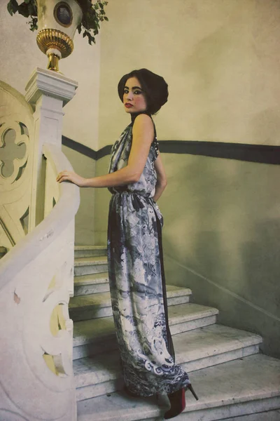 Κομψή γυναίκα στο μακρύ φόρεμα σε vintage σκαλοπάτια — Φωτογραφία Αρχείου