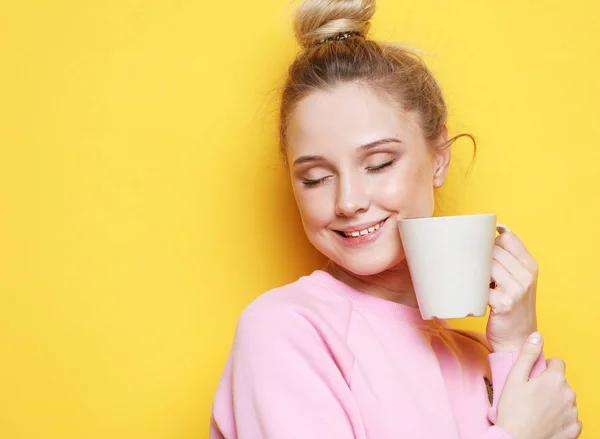 Молода блондинка тримає білу чашку з чаєм або кавою — стокове фото