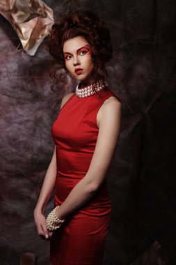Şehvetli, güzel, esmer kadın kırmızı elbise içinde poz veriyor..