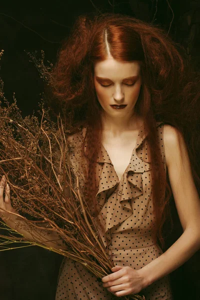 Concept beauté et art : Jeune femme au maquillage lumineux avec des branches sèches — Photo