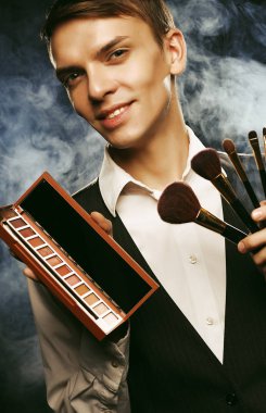 Makyaj fırçaları ve gölge ile poz sanatçı genç erkek makyaj