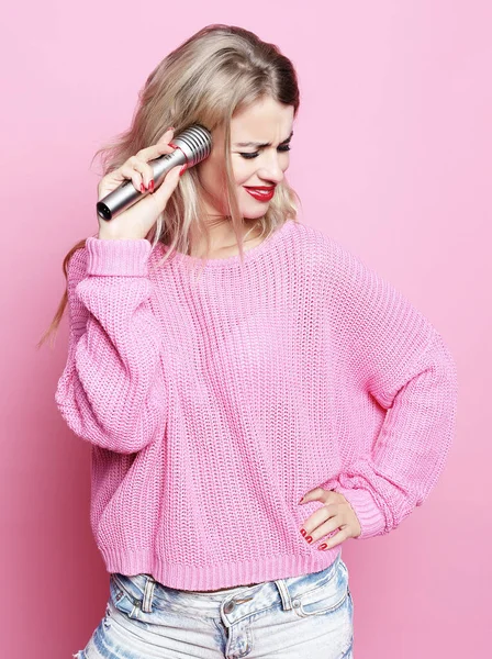 Lifestyle- und People-Konzept: Beauty-Model Sängerin mit Mikrofon vor rosa Hintergrund — Stockfoto