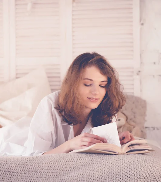 Hermosa mujer rubia leyendo libro en la cama. Concepto relajante — Foto de Stock