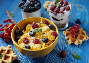 Sağlıklı kahvaltı Mısır gevreği, çilek, gözleme ve süt üzerinde mavi arka plan ile. Yakın çekim.