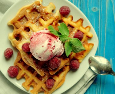 Waffle ahududu Ice cream ve taze ahududu, mavi ahşap arka plan üzerinde nane ile dekore edilmiş kapatmak
