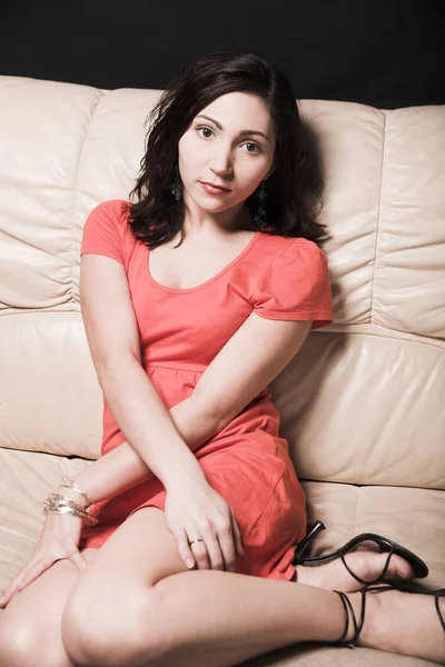 Beautiful woman relaxing on a white sofa — Stock Photo, Image