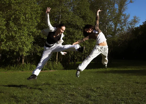 Twee jonge meisje sprong in park — Stockfoto