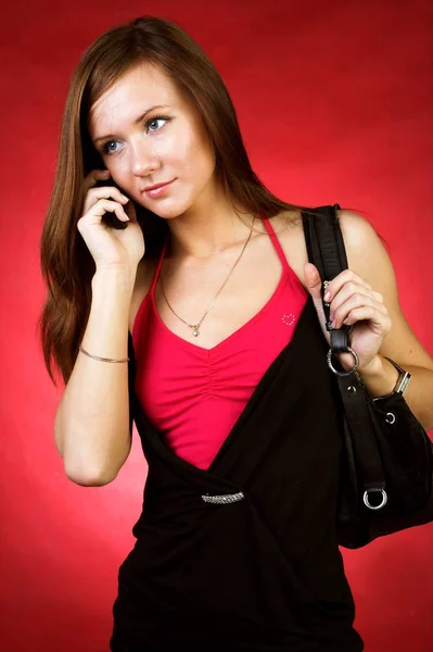 赤い背景の上の若い女性予測に基づく携帯電話 — ストック写真