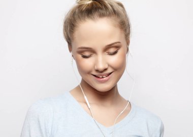 Kulaklıklı güzel genç bir kadın müzik dinliyor.