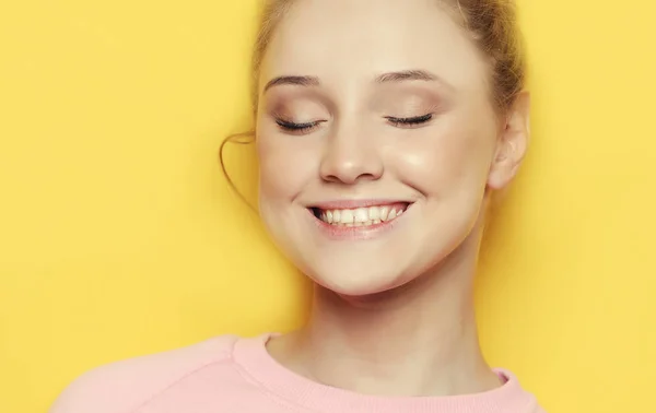 Genç Sarışın kadın kapalı gözler, sarı zemin üzerinde — Stok fotoğraf