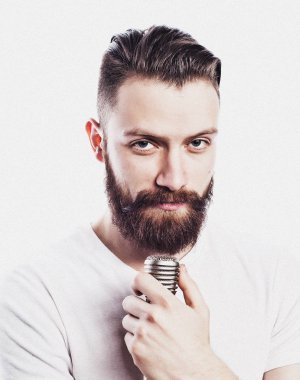 yaşam tarzı ve insanlar kavramı: Genç sakallı adam mikrofon ile şarkı