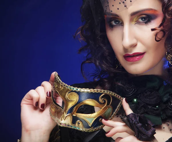 Portrait of woman with artistic make-up holding mask — Stock Photo, Image