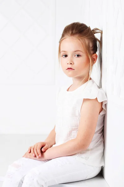 Childrens fashion. Beautiful pensive serious blonde girl in white clothes — Stock Photo, Image