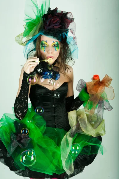 Fashion model with creative make-up blowing soap bubbles — Stock Photo, Image