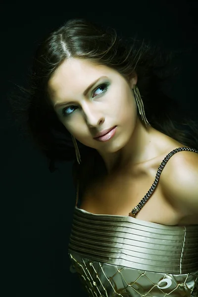 Elegant girl in gold dress, black background — Stock Photo, Image