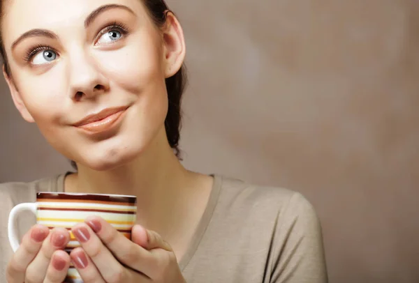 Porträt einer schönen Frau mit einer Tasse Kaffee auf beigem Hintergrund — Stockfoto
