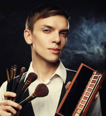 Makyaj fırçaları ve gölge ile poz sanatçı genç erkek makyaj