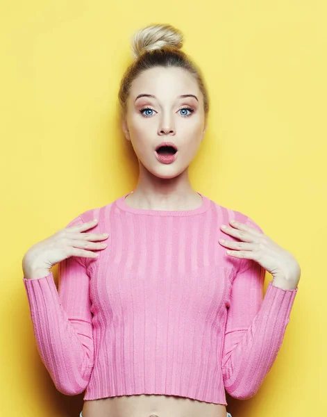 Surprised young blond woman shouting over yellow background. Looking at camera. — Stock Photo, Image