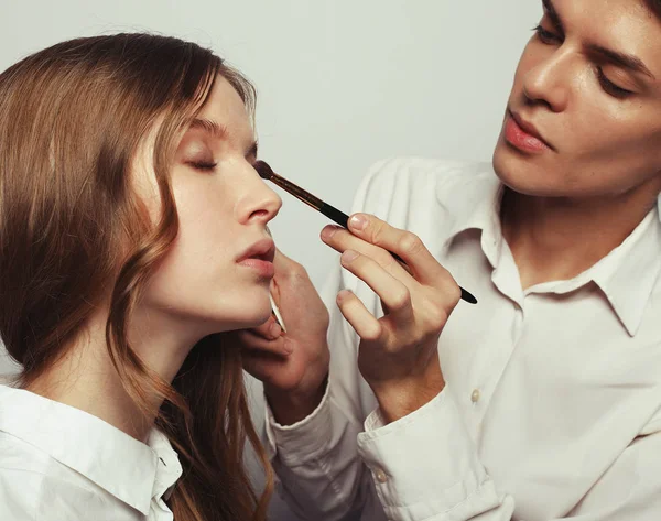 Визажист делает профессиональный макияж молодой женщины — стоковое фото