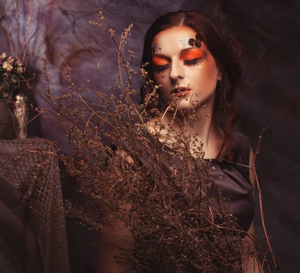 Skönhet och konst koncept: ung kvinna med ljusa gör upp med torra grenar — Stockfoto