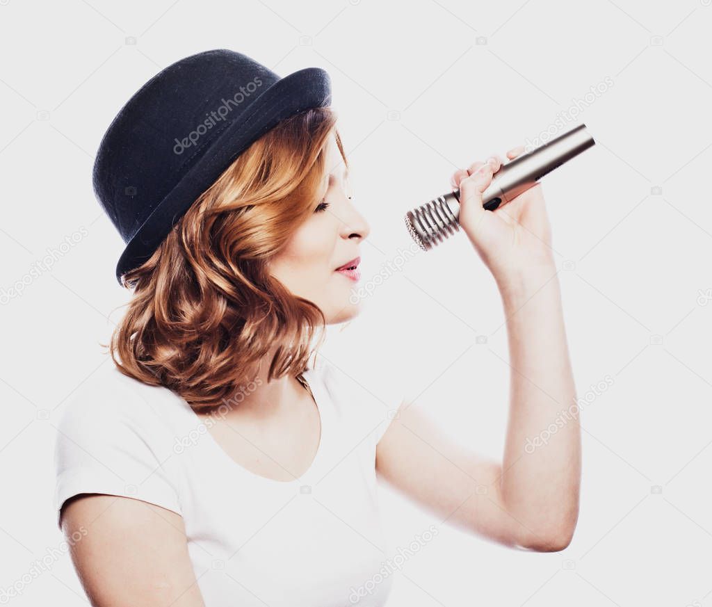 lifestyle and people concept: Beauty model girl singer wearing hat with a microphone