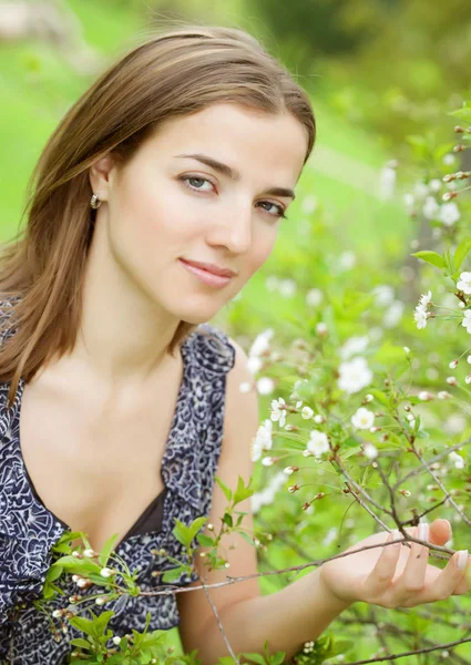 Jonge vrouw in jurk ontspannen in de tuin — Stockfoto