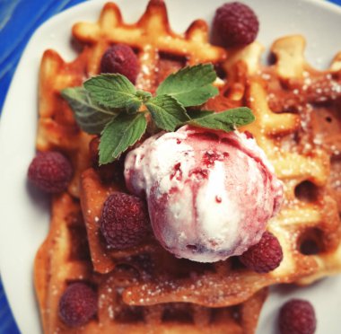 Dondurma ve mavi ahşap arka plan üzerinde taze çilek ile Belçika waffle tabak