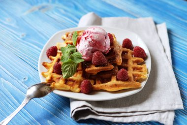 Waffle ahududu Ice cream ve nane ile dekore edilmiş mavi ahşap arka plan üzerinde taze frambuaz