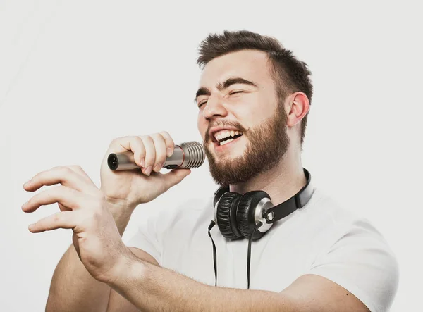 Boy Rocking Out. Image d'un bel homme barbu chantant au micro. Portrait émotionnel d'un homme séduisant avec une barbe sur fond blanc — Photo