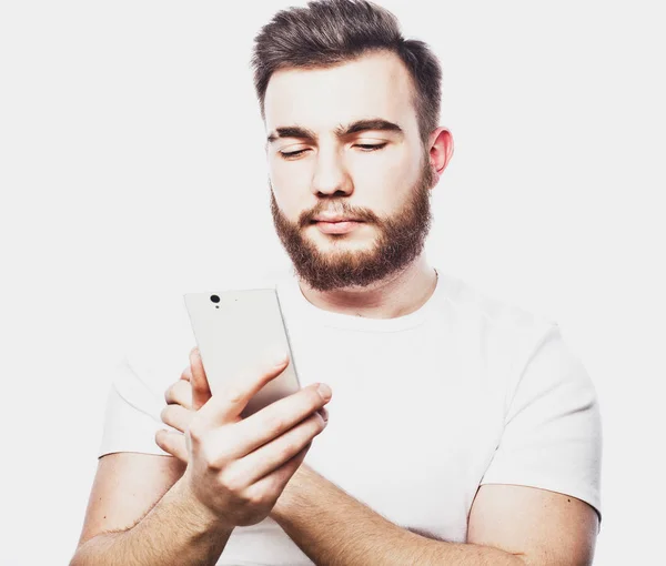 Tehnology and people concept: bärtiger Mann tippt SMS auf weißem Hintergrund — Stockfoto