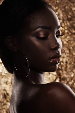 Moda studio bir olağanüstü güzel Afro-Amerikan model altın arka plan üzerinde kapalı gözlerle portresi