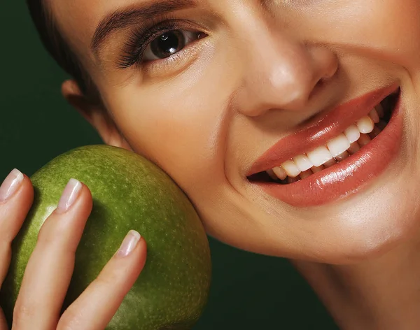 Mujer joven con manzana verde sobre fondo verde — Foto de Stock