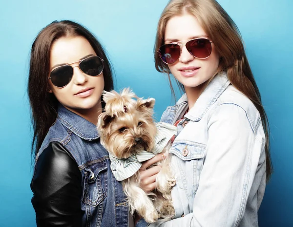 Спосіб життя і концепція людей: двоє молодих дівчат друзі стоять разом і тримають собаку — стокове фото