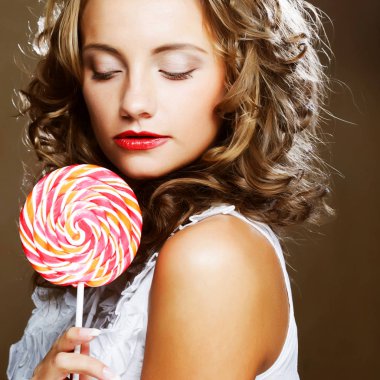 bir lolipop onun elinde olan kıvırcık kız 
