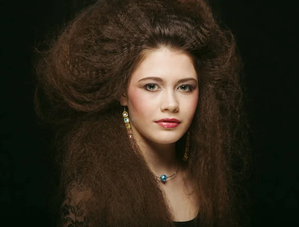 Mooie jonge vrouw met krullend haar en avond make-up. Sieraden en Beauty concept. Mode kunst foto. — Stockfoto
